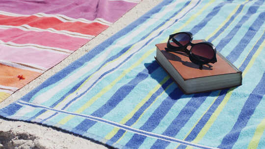 毛巾上的太阳镜和书籍视频素材模板下载