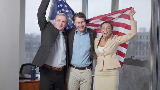 乐观的美国商业团队在办公室悬挂国旗