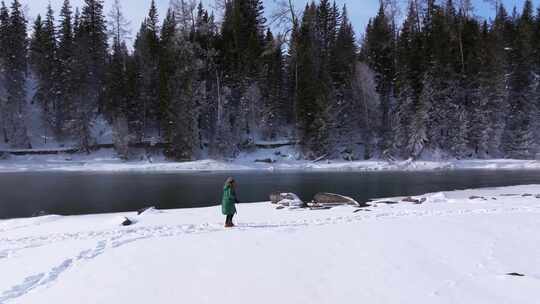 航拍新疆阿勒泰冬季喀纳斯游客在雪地上游玩