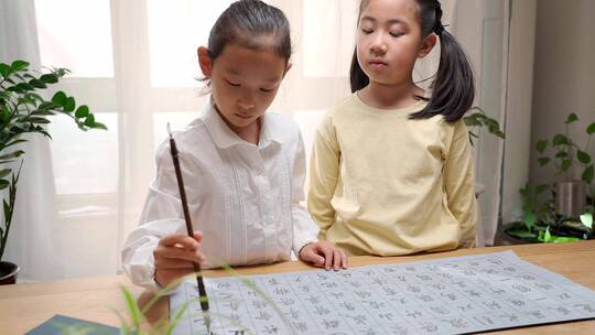 两个用字帖练习毛笔字的东方女孩视频素材模板下载