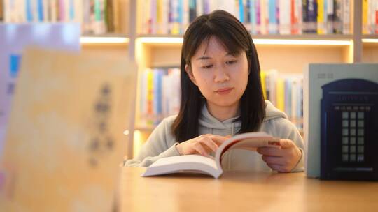 年轻女子图书馆在书架前翻看书本学习