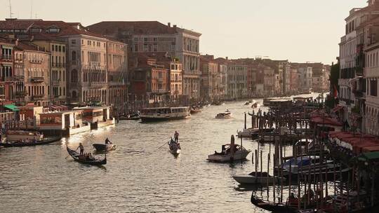 威尼斯船夫撑船穿过意大利威尼斯的绿色运河