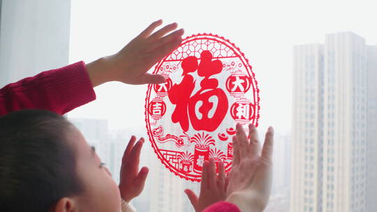 中国母子春节贴窗花