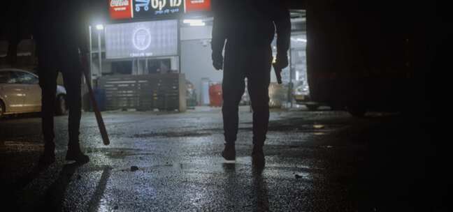 两个全副武装的人晚上站在杂货店外面