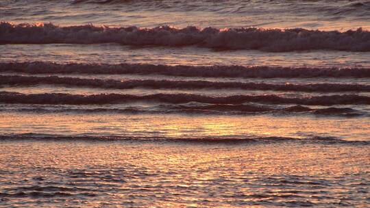 落日余晖映照的海面波浪