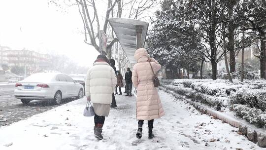 大雪中走向公交站牌的市民