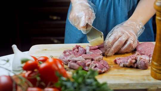 一个人在菜板上切肉