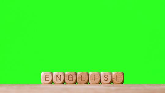 绿幕背景前的ENGLISH木制字母块