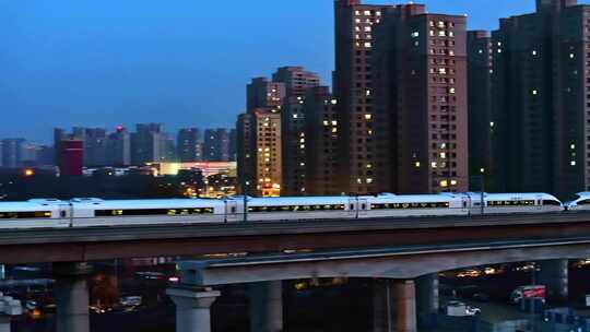一辆高铁快速穿梭在繁华城市里