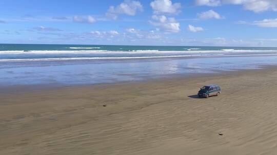 男人在海边的沙滩上开车
