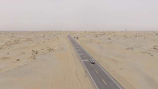 航拍越野车行驶在新疆塔克拉玛干沙漠公路上