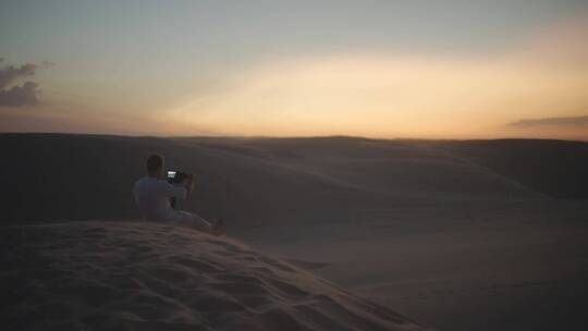 男人在沙漠拍摄日落美景