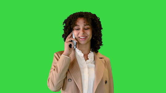 美国女人在绿屏上行走时打电话，色度键。