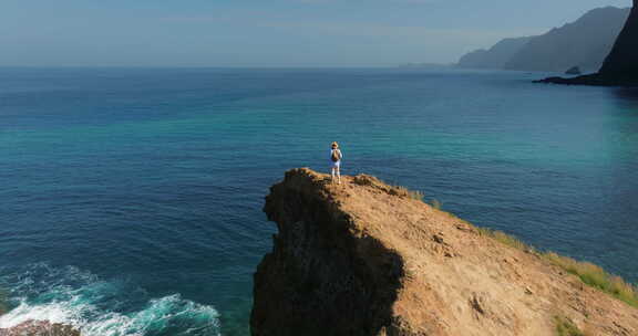 戴帽子的女人享受海洋女人站在悬崖边的高处