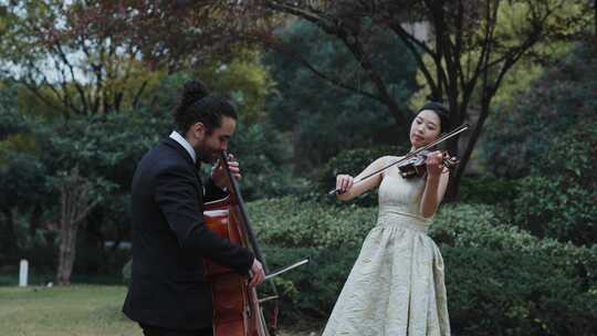 美女小提琴和外国人大提琴住宅小区草坪演奏