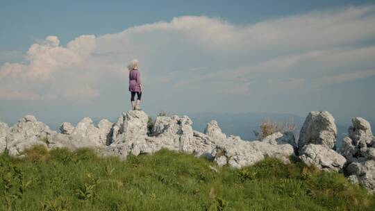 女人站在岩石上看风景