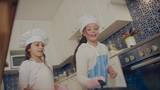 两个小女孩在厨房颠锅高清在线视频素材下载