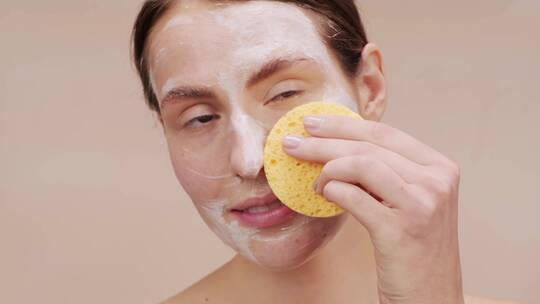 用肥皂和海绵洗脸的女人视频素材模板下载