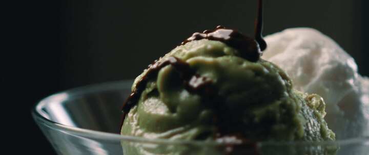 巧克力酱倒在绿色和白色的冰淇淋上