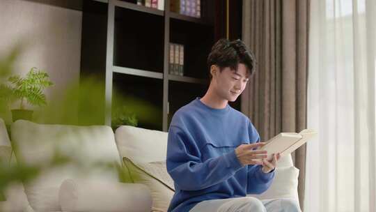 青年男士居家客厅看书翻阅书籍阅读享受生活