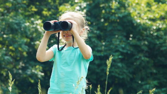 女孩在草地上透过望远镜看远处视频素材模板下载