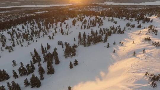 在白雪皑皑的冬季景观上无人机拍摄日落