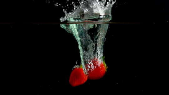 草莓掉入水中溅起水花的瞬间