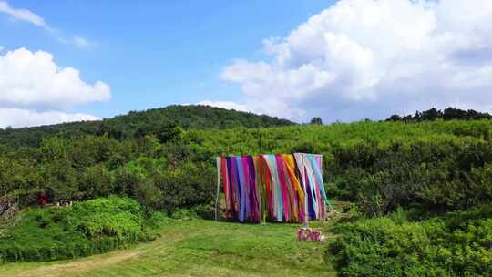 宣传片航拍蓝天白云野外山坡彩带飘动