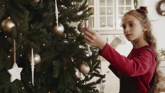 女孩整理圣诞树上的装饰
