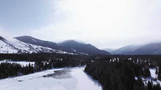 航拍新疆冬季喀纳斯神仙湾晨雾雪山森林雪景