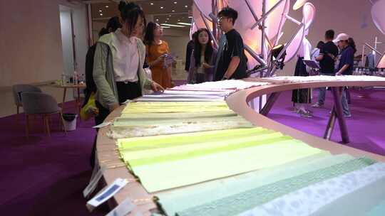 展会内人们查看布料素材