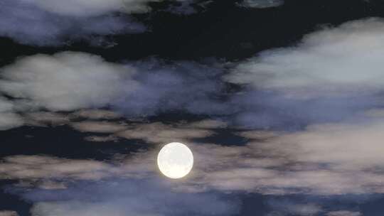 一轮满月透过夜间的云层清晰可见