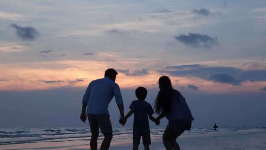 夕阳海边一家人一家三口幸福生活