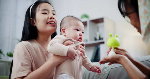 两个女人在家里客厅的沙发上开心地和一个小