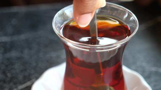 在传统玻璃杯中手工搅拌土耳其茶