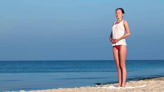 女孩站在海边练瑜伽