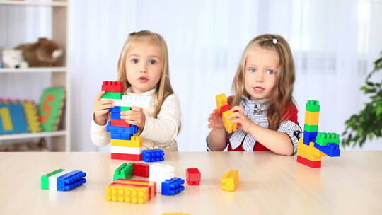 两个金发小女孩在玩积木
