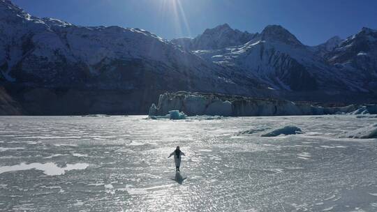 航拍一个人奔跑在来古冰川的冰面上