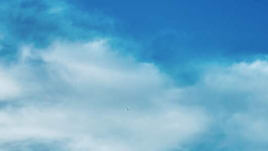 蓝天白云下飞机飞过