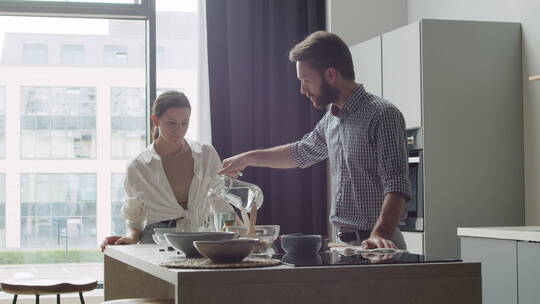 幸福的夫妇在现代厨房喝水