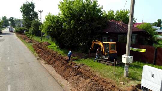 工人用挖掘机在乡村铺设电缆