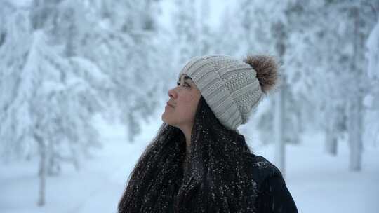 芬兰拉普兰北极圈下雪的冬季仙境中，女孩抬