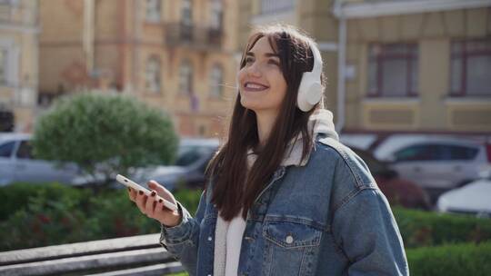 在户外听着音乐散步的女人