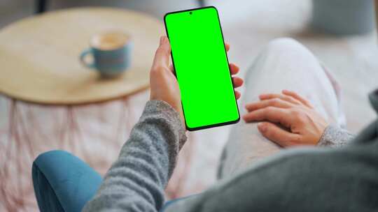 坐在沙发上看手机是绿幕的手机可以添内容