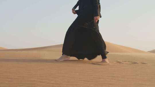 一个女子光脚走在沙漠里面