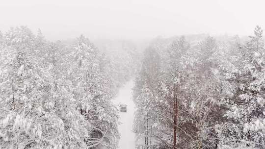 一辆汽车在被雪覆盖的道路上的无人机镜头