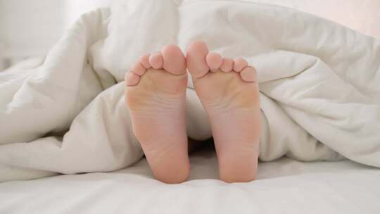 卧室床上毯子下的脚  舒适