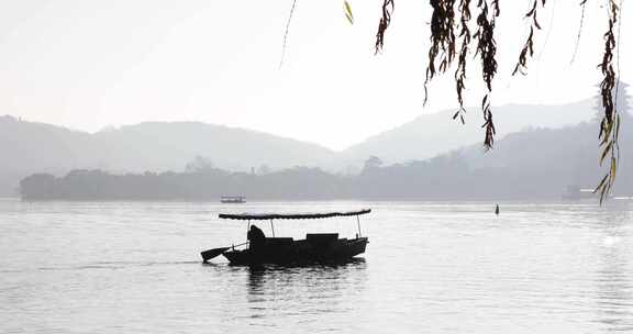 杭州西湖湖面游船手划船晨曦