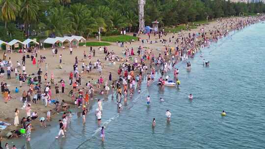 海南三亚椰梦长廊海岸线上游玩拍摄的游客