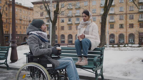 穆斯林妇女和她的残疾朋友坐在轮椅上